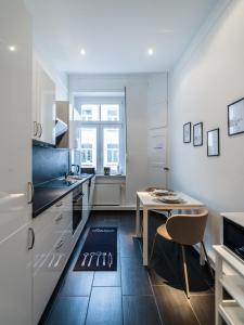 eine Küche mit einem Tisch und einem Esszimmer in der Unterkunft Hochwertige Altbauwohnung im modernen Stil in Wiesbaden - Küche - Terrasse - WLAN - Zentral in Wiesbaden