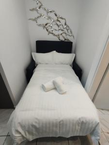 a bed with two white towels on top of it at Kentrikon Guest House in Xanthi