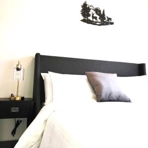 a bedroom with a bed with a black headboard and a night stand at Mountain Retreat: Brand New 2BR Condo in Canmore