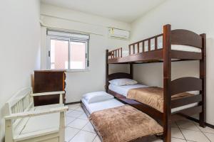 a room with two bunk beds and a window at Confortável apto a 3min da praia de Mariscal CRA304 in Bombinhas