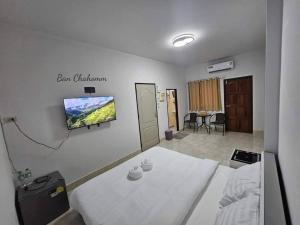 - une chambre à l'hôpital avec un lit et une télévision murale dans l'établissement Ban Chahomm Guesthouse, à Betong