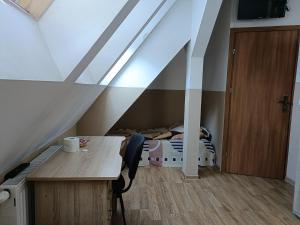 Pokój z biurkiem i łóżkiem na poddaszu w obiekcie Pokoje na wynajem Gdańsk w Gdańsku