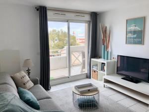 un salon avec un canapé et une télévision dans l'établissement Côté Bassin, à Arcachon