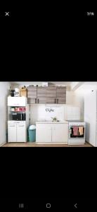 - une petite cuisine avec des armoires et des appareils blancs dans l'établissement Roland, à Bordeaux