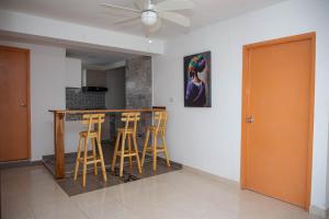 a kitchen with a bar with stools and a painting on the wall at CASA PETRA in Cartagena de Indias
