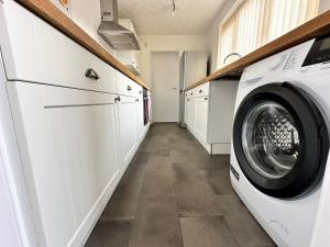 een wasruimte met een wasmachine en droger bij 4 bed 3 bedroom home near Middlesbrough centre in Middlesbrough