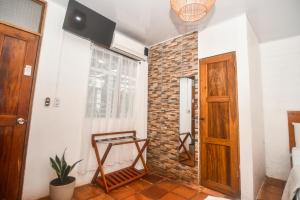 Habitación con pared de ladrillo y puerta de madera. en Hotel Aldea Pura Vida en Puntarenas