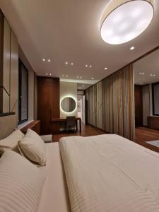 una camera con un grande letto bianco e una scrivania di Sky-High Luxury - City's Best View a Novi Sad