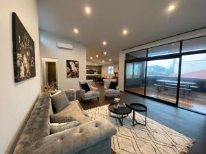 a living room with a couch and a table at Luxury Escape in CBD - entire brand new home in Tauranga