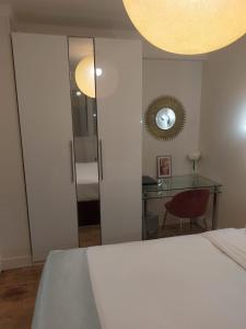 una camera con letto, tavolo e specchio di location chambre chez l'habitant a Épinay-sur-Seine