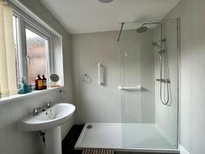 een witte badkamer met een douche en een wastafel bij 4 bed 3 bedroom home near Middlesbrough centre in Middlesbrough