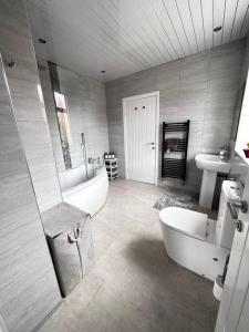 y baño con bañera, aseo y lavamanos. en Spacious Modern Duplex Apartment en Rochdale