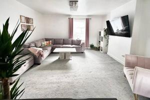a living room with a couch and a table at Spacious Modern Duplex Apartment in Rochdale