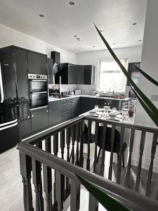cocina con electrodomésticos de acero inoxidable y mesa en Spacious Modern Duplex Apartment en Rochdale