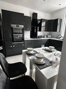 una cocina con una mesa con platos y copas de vino en Spacious Modern Duplex Apartment en Rochdale