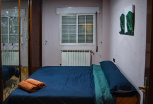 a bedroom with a blue bed in a room with a window at Apartamento Abrante in Madrid