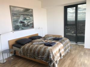 1 dormitorio con cama y ventana grande en Unik udsigt og beliggenhed, en Aarhus