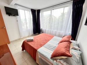 een kleine slaapkamer met een bed en een raam bij Lindo Apartaestudio Centro Pereira in Pereira