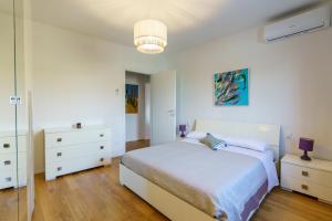 a white bedroom with a bed and two night stands at La casina dei Praticelli in Castelfiorentino