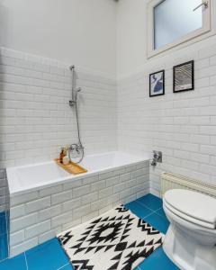 a white bathroom with a tub and a toilet at Szondi Residence in Budapest