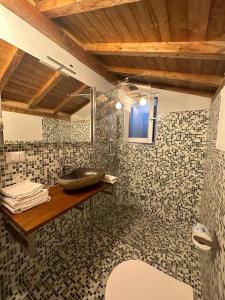 a bathroom with a sink on a tiled wall at Residenza ammiraglio Filippo in Varigotti