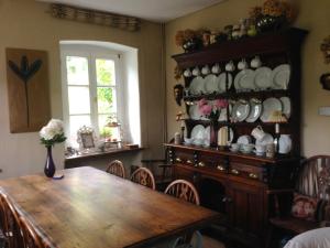 a dining room with a table and a china cabinet at All Seasons Bed & Breakfast in Kerpen