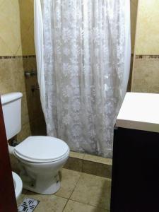 baño con aseo y cortina de ducha blanca en Abasto 2062 en Rosario