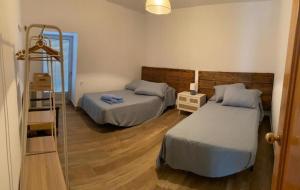 Un dormitorio con 2 camas y una escalera. en CASERIO LA SEVILLANA, en Baeza