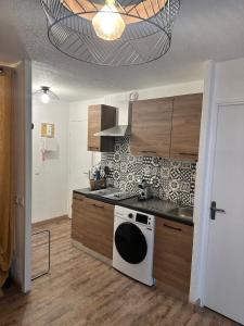 uma cozinha com um fogão e um forno branco em T2 tout équipé floralie 2 em Le Grau-du-Roi