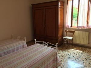 セラヴェッツァにあるVilla Chiaraのベッドルーム1室(ベッド2台、木製キャビネット付)