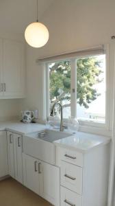 une cuisine blanche avec un évier et une fenêtre dans l'établissement Venice Canals & Beach Guest House, à Los Angeles