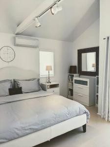 a white bedroom with a bed and a mirror at Venice Canals & Beach Guest House in Los Angeles