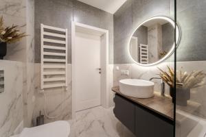 a bathroom with a sink and a mirror at 77 views apartments by INSHI in Lviv