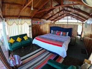 a bedroom with a bed and a couch in a room at Pachamama Titicaca Lodge in Puno +9 photos