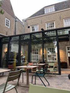 een patio met een tafel en stoelen voor een gebouw bij Stadsklooster Dordt Hotel&Hostel in Dordrecht
