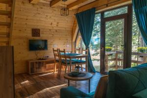 a living room with a table and chairs in a cabin at Oaza Jela in Mitrovac