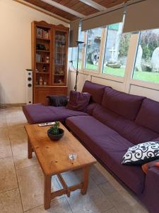 uma sala de estar com um sofá roxo e uma mesa em Cabana Monte do Castro em Porto do Son