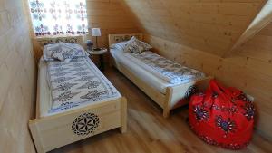 a room with two beds and a red bag in it at Domki Białka & Apartamenty in Białka Tatrzanska +47 photos