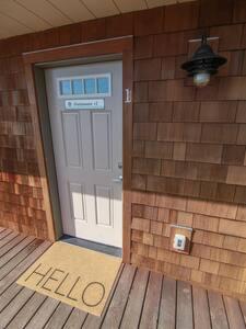 a door to a house with a hello sign in front at Charming Hideaway Overlooking The Astoria Waters in Astoria, Oregon