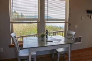 a dining room table with two chairs and a window at Charming Hideaway Overlooking The Astoria Waters in Astoria, Oregon
