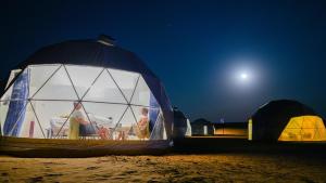 uma tenda cúpula na praia à noite em Luxury Desert Camp em Al Wāşil