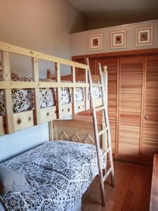 a bedroom with a bunk bed with a ladder at Historic Astoria Waterfront Views & Vintage Vibes in Astoria, Oregon