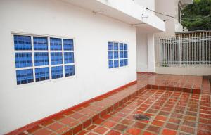 a room with a brick floor and two windows at CASA PETRA in Cartagena de Indias