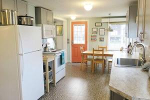 a kitchen with a white refrigerator and a table at Seaside OR- Chic Family Beach Escape & Fast Wi-Fi in Seaside