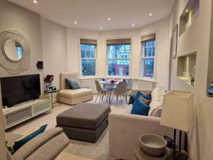 a living room with a couch and a tv at Quintessentially 'London' flat in London