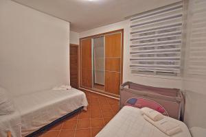 um pequeno quarto com 2 camas e uma janela em InHome Apartment em Cabo Negro