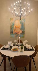 una mesa con un plato de comida y una lámpara de araña en Exclusive, cosy, elegant Frogner apartment in the center of Oslo, en Oslo