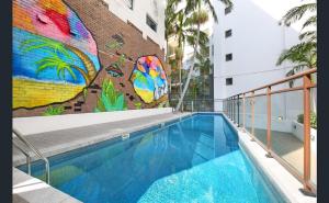 ein Wandbild an der Seite eines Gebäudes mit Pool in der Unterkunft It's Paradise Here, Guesthouse with Breakfast and 2 cats in Wollongong