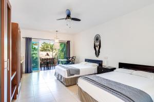 a hotel room with two beds and a balcony at Maia Suites Cozumel in Cozumel