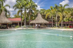 a pool at a resort with palm trees at HOTEL CAMPESTRE Palma in Villavicencio